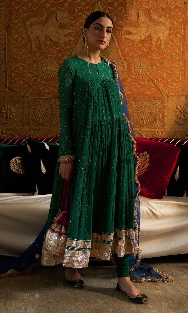 emerald green silk festive tiered anarkali dress Make a statement with this bold and versatile green fusion wear! Get two outfits in one and style it as you like with or without the jacket. A perfect blend of
